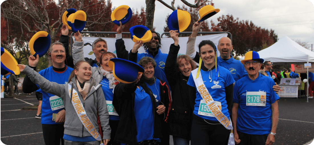 photo de groupe de personnes avec des chapeaux jaune et bleu à la fin de la course courstache de 2019