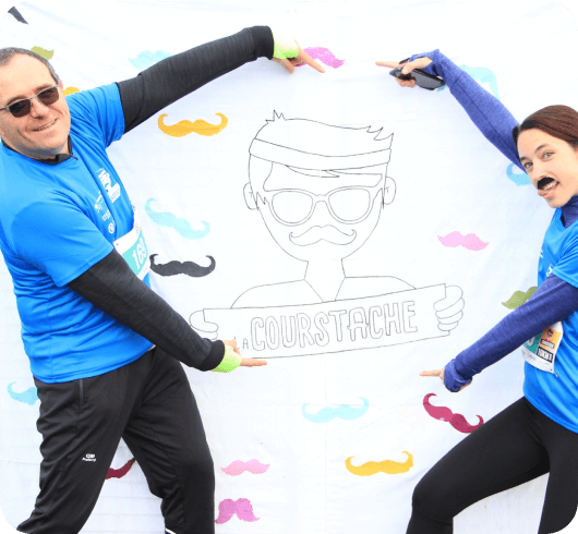 une femme et un homme posant devant le logo courstache à la fin de la course courstache 2019